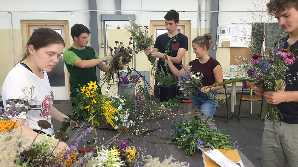 Schülerinnen und Schüler binden Blumensträuße