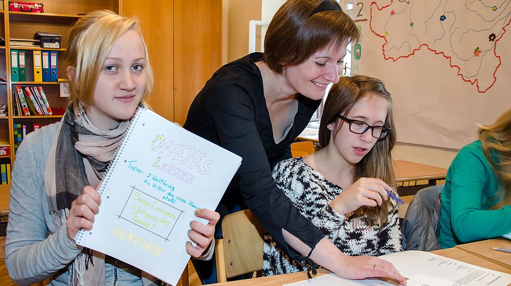 Lehrerin und Schülerinnen beim Unterricht im Klassenzimmer 