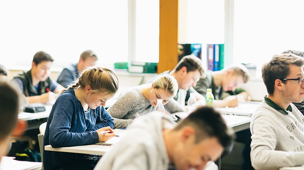 Schülerinnen und Schüler sitzen in der Klasse während des Unterrichts