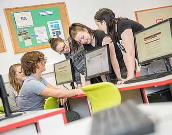 Schülerinnen und Schüler arbeiten gemeinsam am Computer