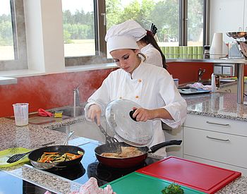 Schülerin kocht in der Schulküche
