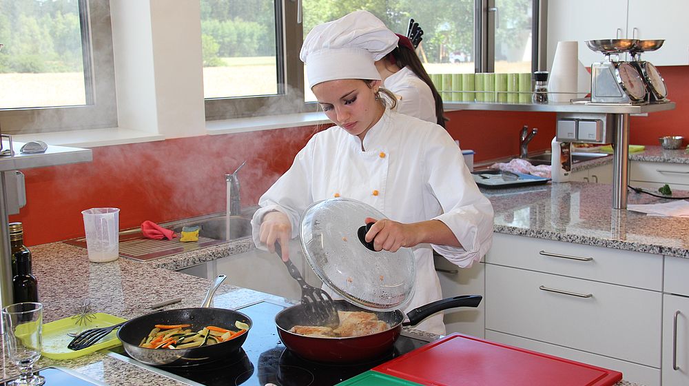 Schülerin kocht in der Schulküche