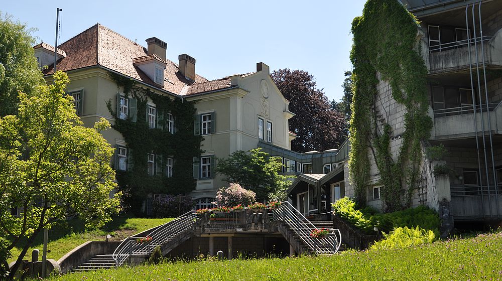 Stiegenaufgang und Schulgebäude mit begrünter Fassade