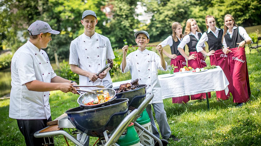 Schüler und Schülerinnen beim Grillen im Garten