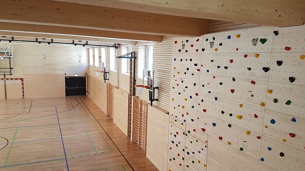 Blick in die Turnhalle mit Holzwand und Holzdecke