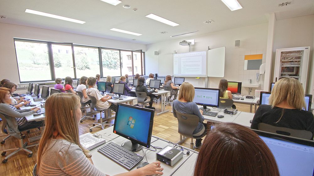 Schülerinnen und Schüler arbeiten im Computerraum am PC