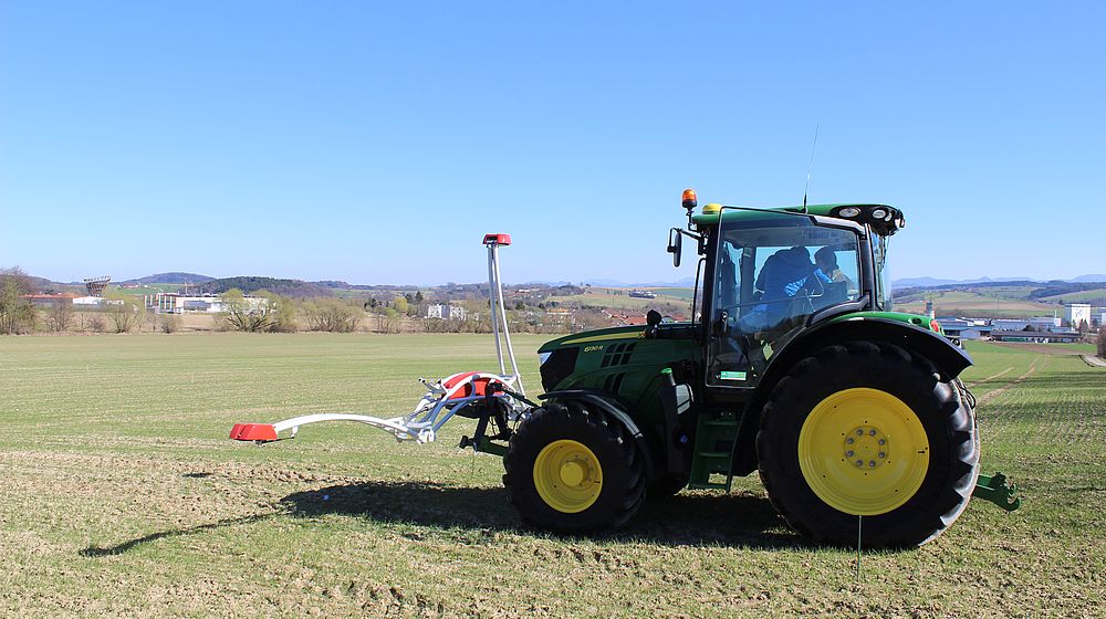 Schüler sitzen im Traktor auf einem Feld