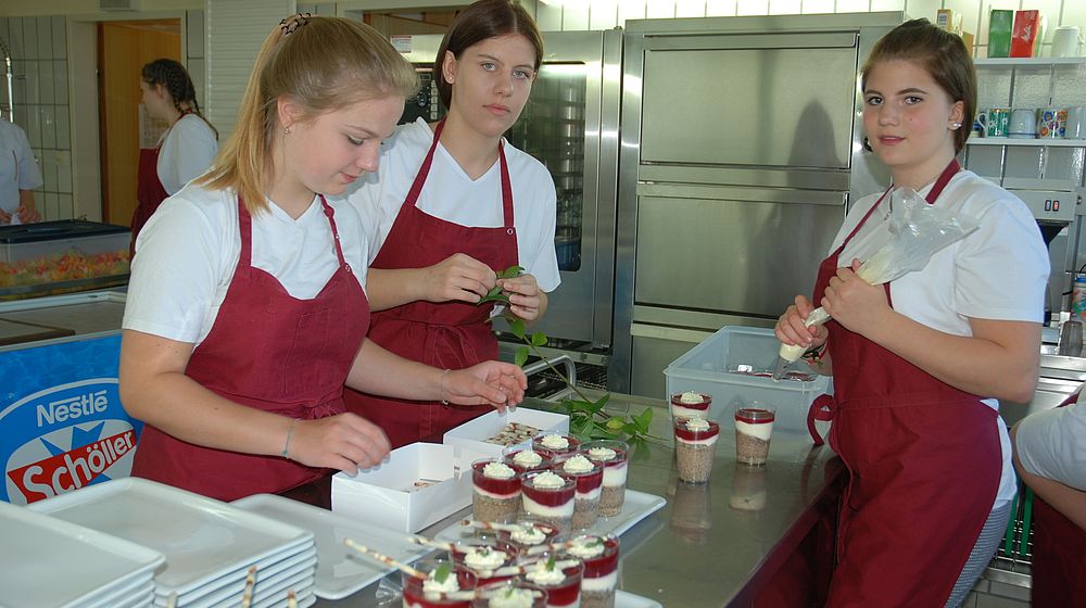Schülerinnen in der Küche beim Zubereiten einer Süßspeise