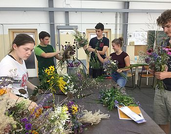 Schülerinnen und Schüler binden Blumensträuße