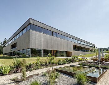 Modernes Schulgebäude aus Holz und Glas mit Außenanlage