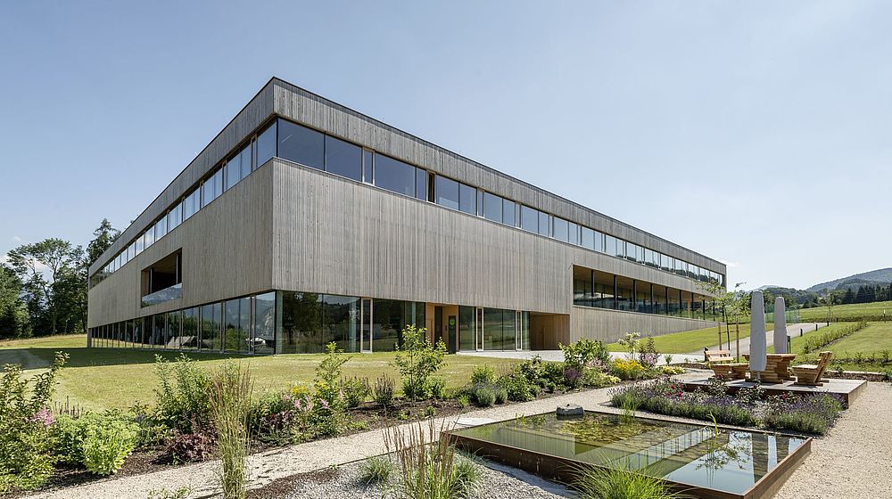 Modernes Schulgebäude aus Holz und Glas mit Außenanlage