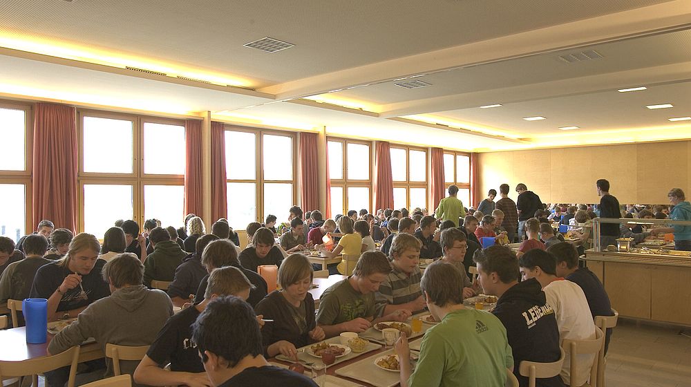 Schülerinnen und Schüler beim Essen im Speisesaal