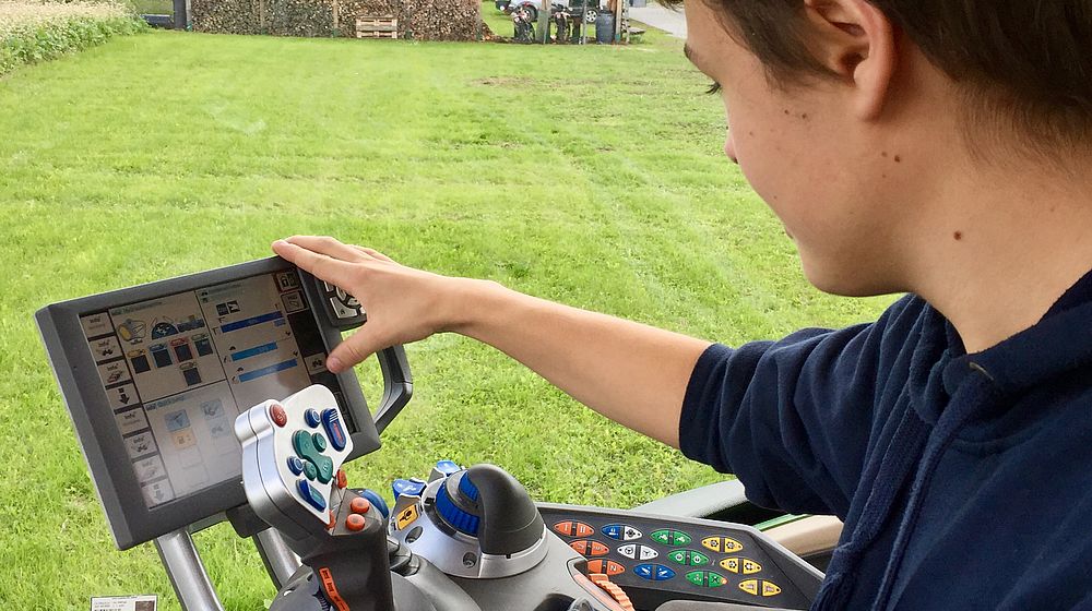Schüler bedient Schaltflächen des automatisierten Traktors
