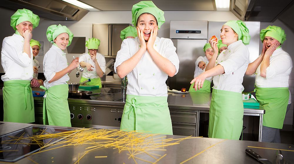 Schülerinnen und Schüler beim Arbeiten in der Küchenpraxis