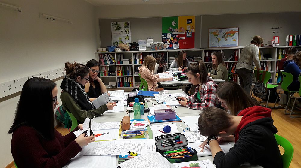 Schüler und Schülerinnen erledigen Schulaufgaben in der Bibliothek