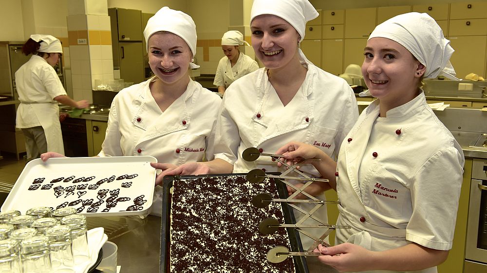 Schülerinnen präsentieren Dessert auf Backblech