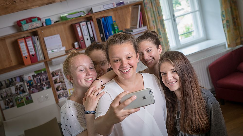 Schülerinnen machen ein Selfie im Internatszimmer