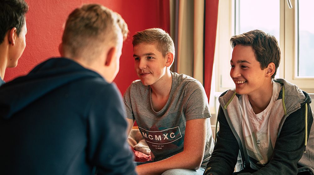 Schüler sitzen im Internatzimmer zusammen