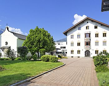 Helles Schulgebäude neben lokaler Kirche