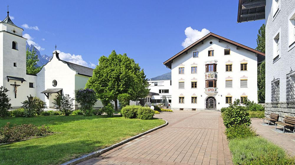 Helles Schulgebäude neben lokaler Kirche