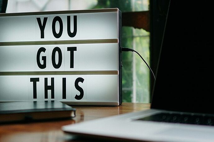 Laptop auf dem Tisch mit einem Schild "You got this!"