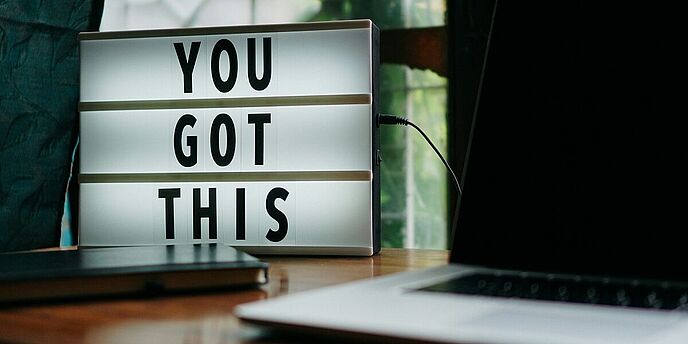 Laptop auf dem Tisch mit einem Schild "You got this!"