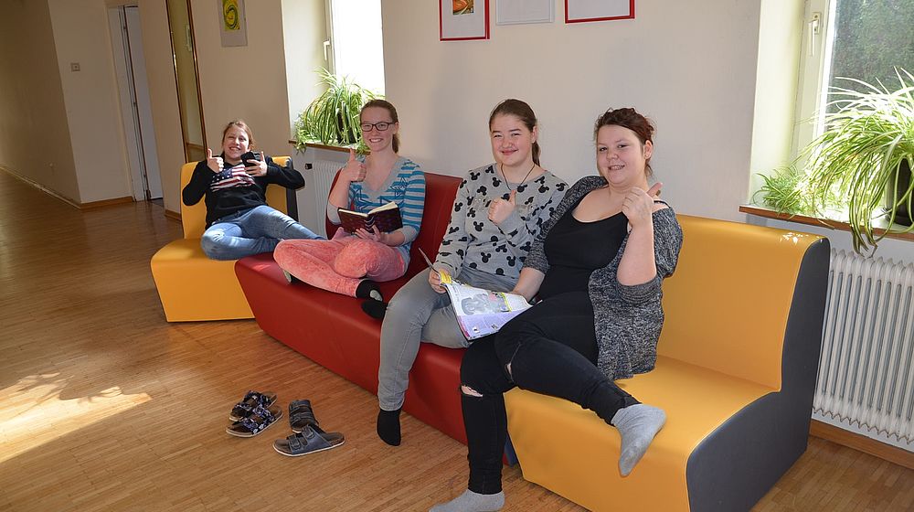 Schülerinnen sitzen auf Couch im Internatsbereich