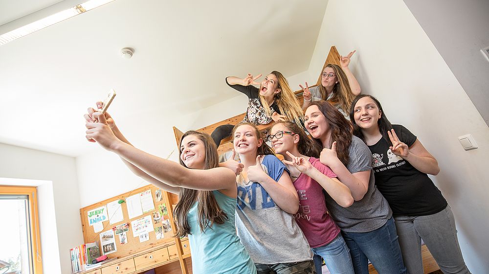Schülerinnen machen im Internatszimmer ein Selfie